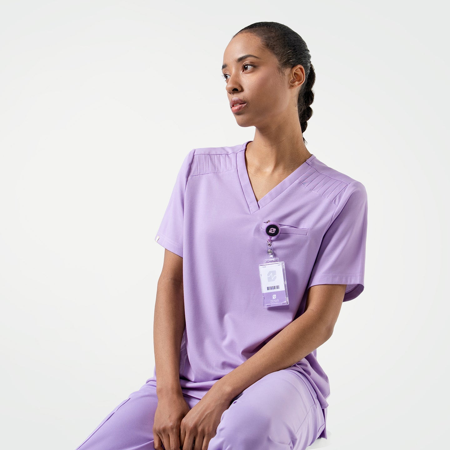 Image of Lavender  scrub top with shoulder details, paired with matching scrub pants